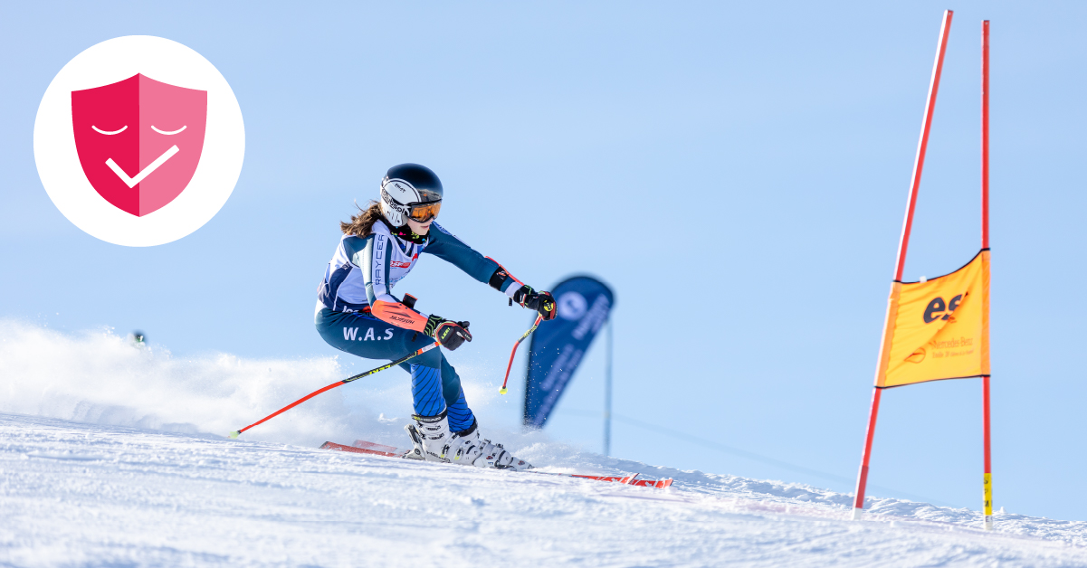 Young female ski racer competing in ISSC, covid guarantee badge